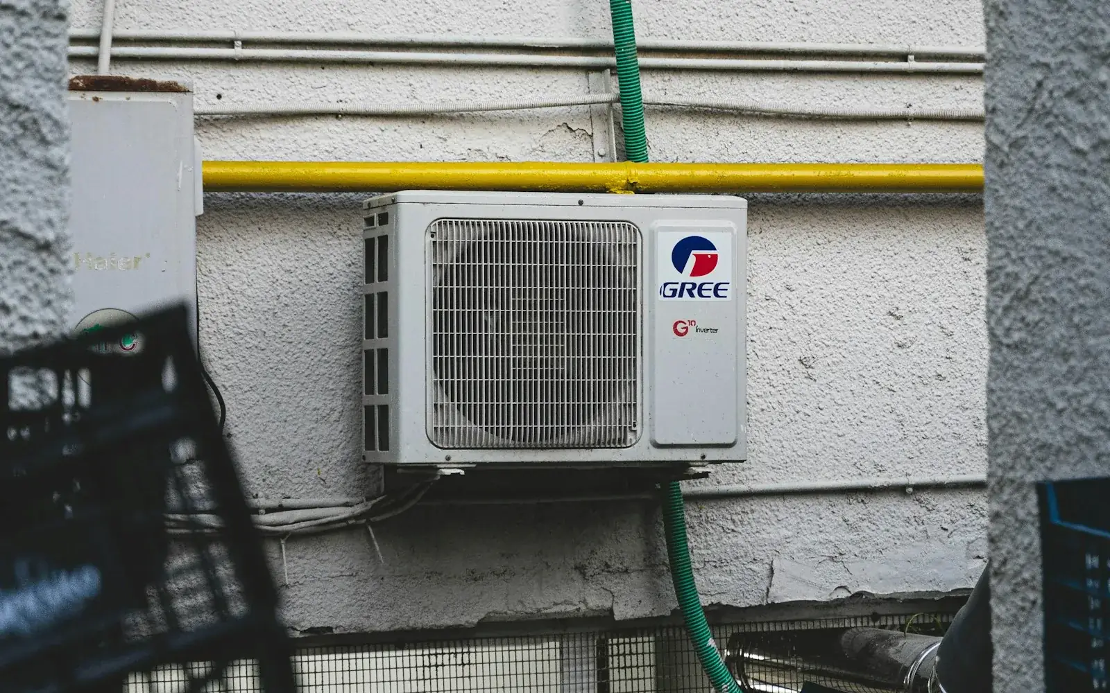 Wall-mounted outdoor air conditioning condenser and connecting pipework